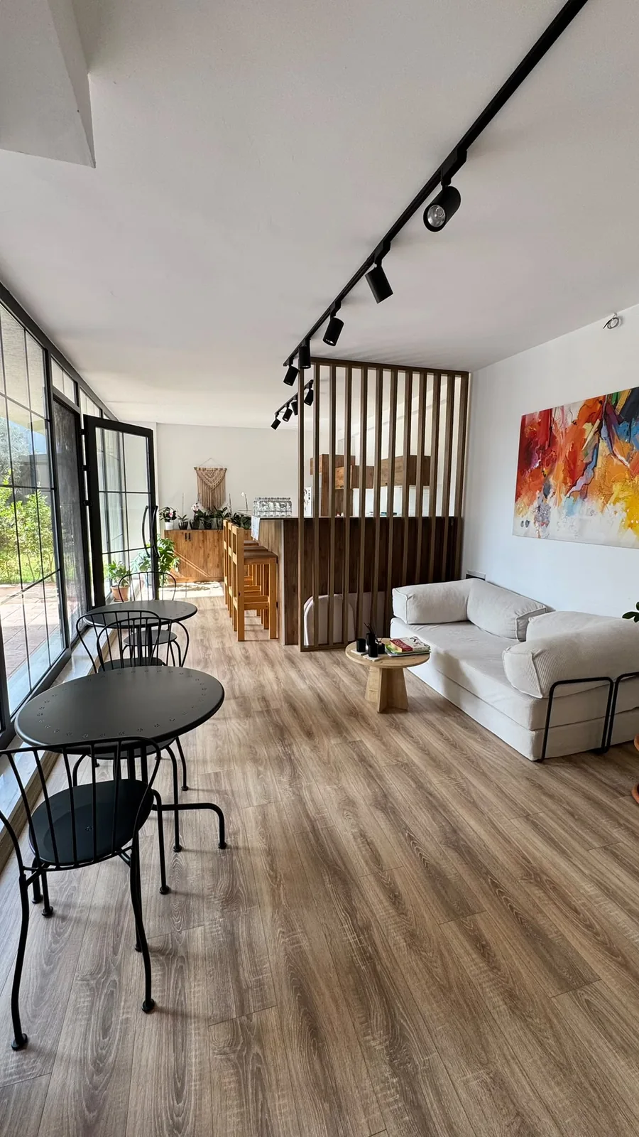 Wonder Pilates Studio’daki koltuk, sehpalar ve ahşap bölmeler bulunan dinlenme alanı