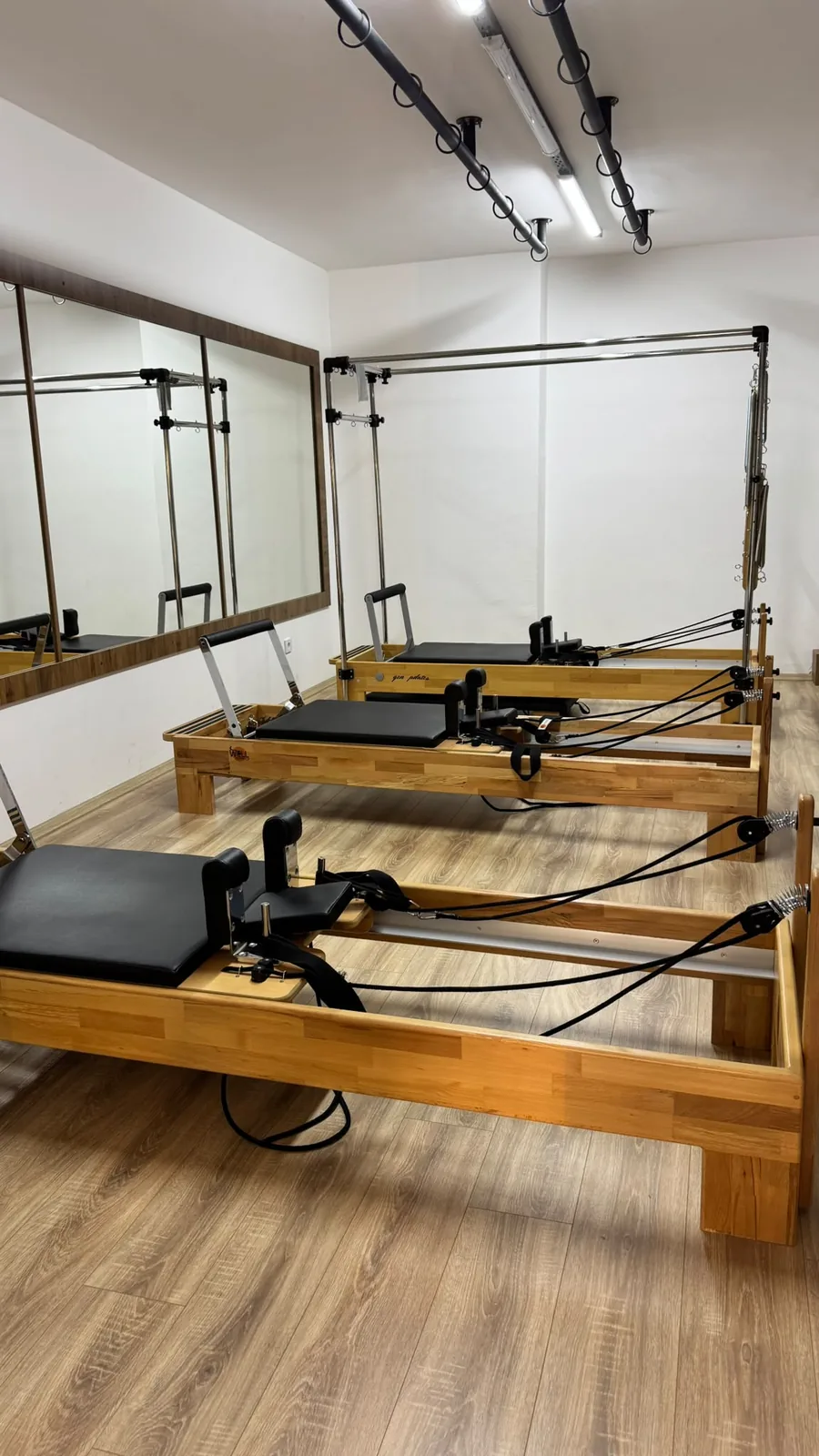 Wonder Pilates Studio’daki aynalı salonda ahşap reformer ekipmanları